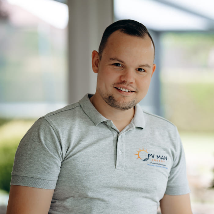 Porträt von Tammo Mansholt, einem Photovoltaik-Experten, der ein graues Polohemd mit dem Firmenlogo trägt.